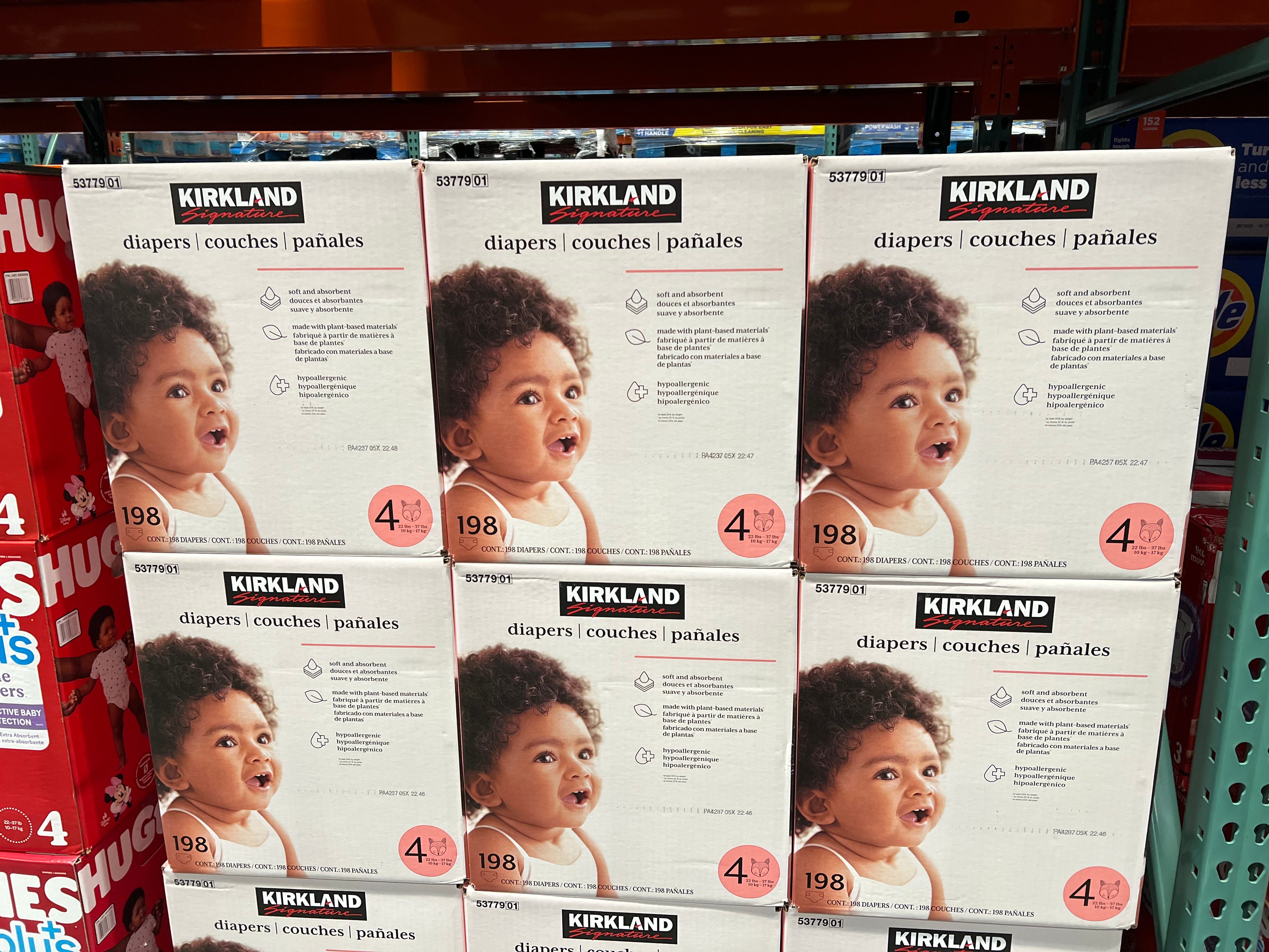 Boxes of Kirkland Signature diapers with a picture of baby on the front on a shelf at Costco.