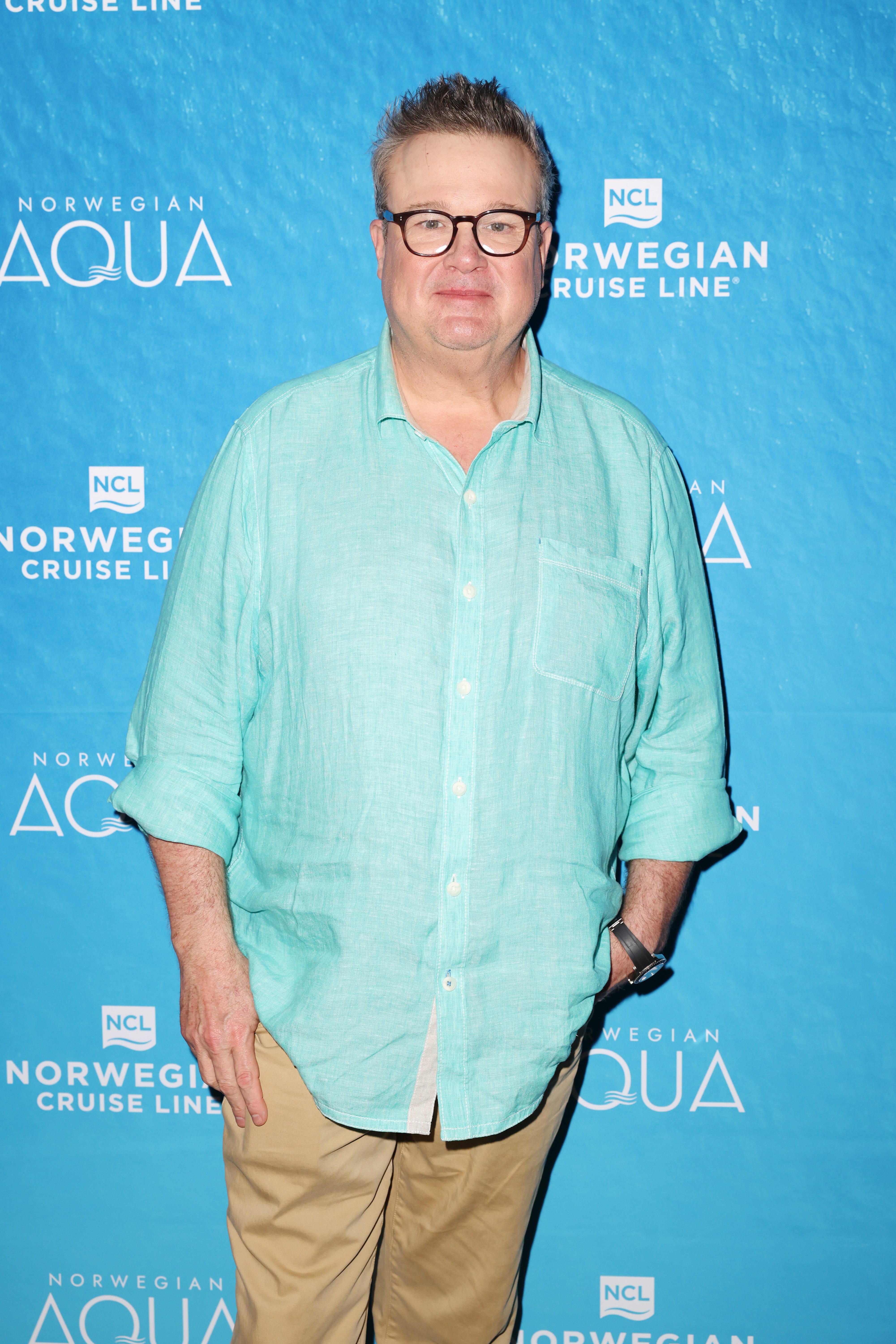 Eric Stonestreet in a blue shirt at a cruise event.