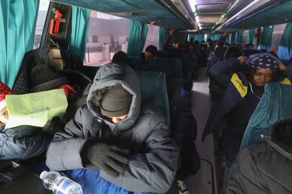 Irregular Nigerian migrants board a bus at the offices of the department of combating illegal migration, tasked with coordinating deportations of foreigners who are in the country illegally with the International Organization for Migration (IOM), on the way to Tripoli's Mitiga International Airport on March 18, 2025.