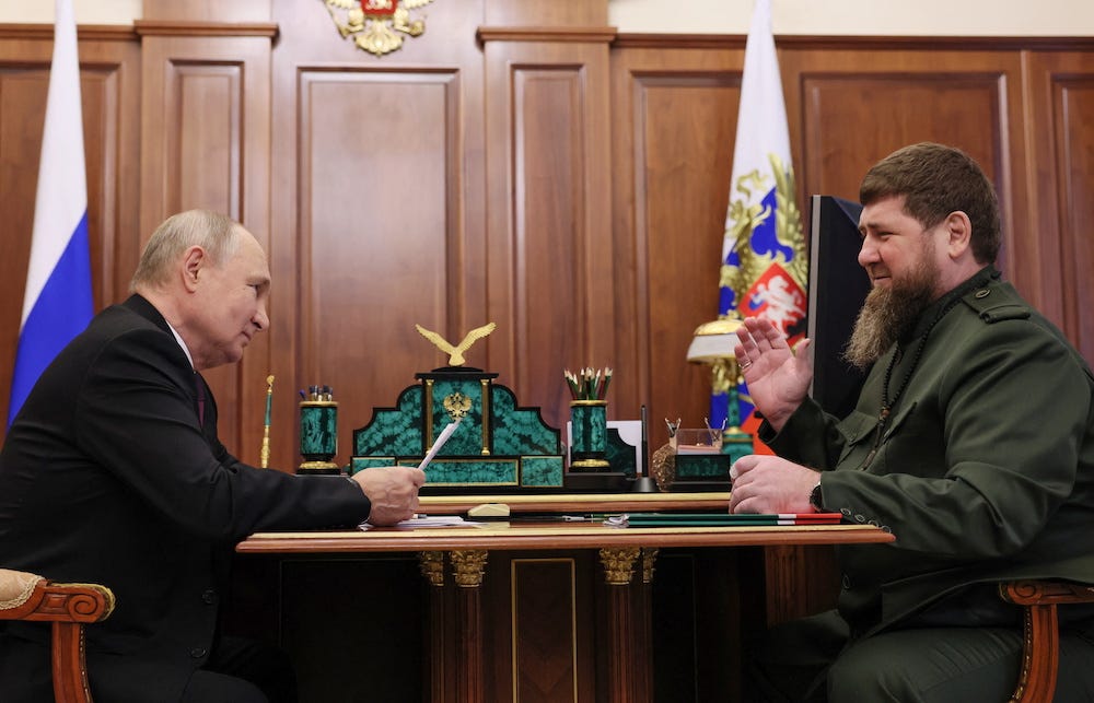 Russian President Vladimir Putin is viewed from the side seated oppositeChechen leader Ramzan Kadyrov in a wood paneled room during a meeting in Moscow, Russia, September 28, 2023. Image provided by state media.