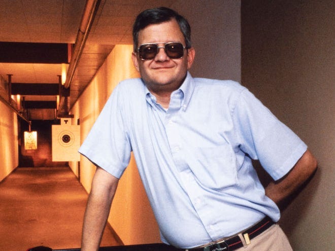 Portrait of American author Tom Clancy (born Thomas Leo Clancy Jr, 1947 - 2013) as he poses in his home rifle range, Prince Frederick, Maryland, August 1990.