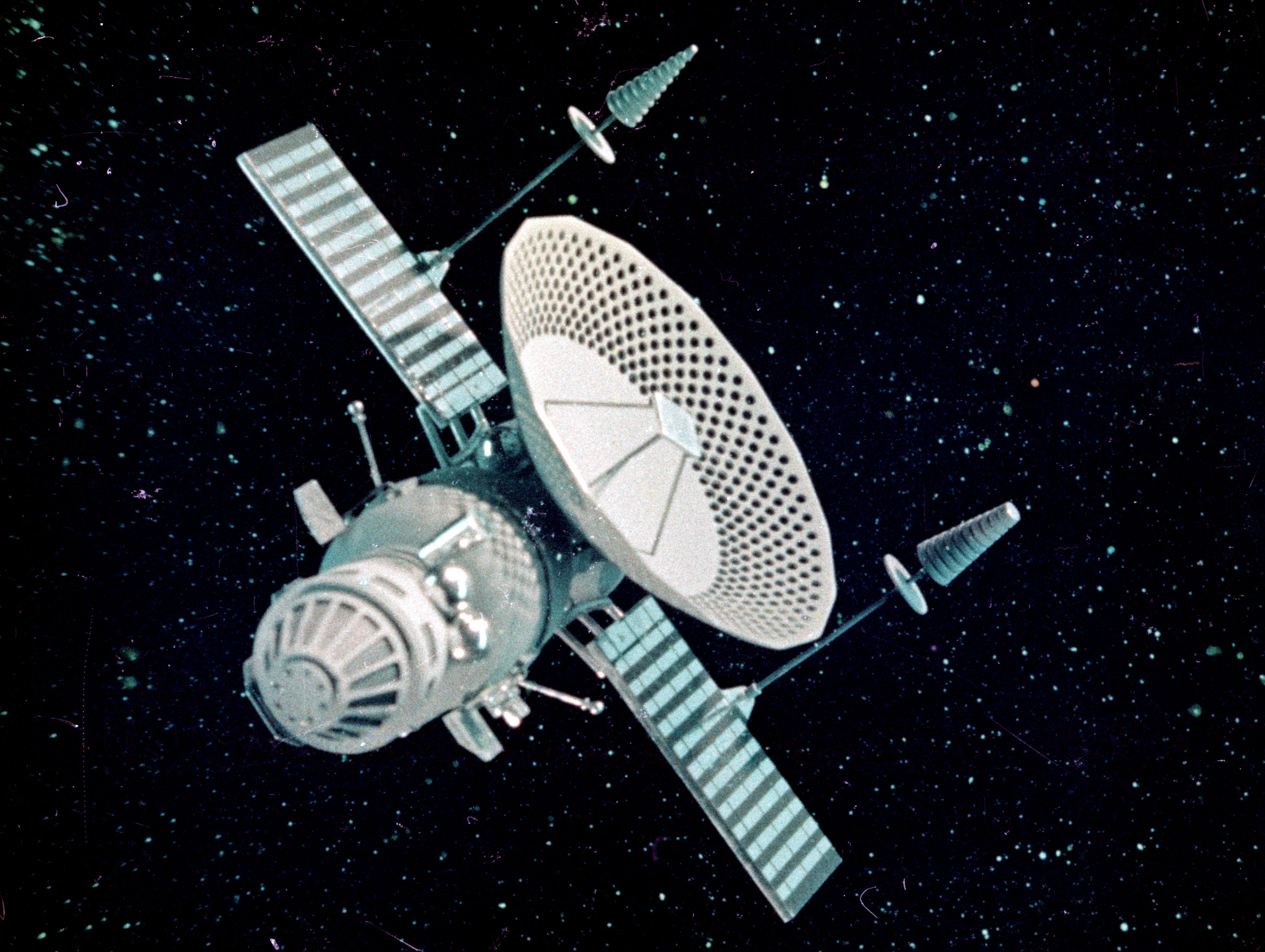 blue and white spacecraft with dish and antennas and solar panels in space