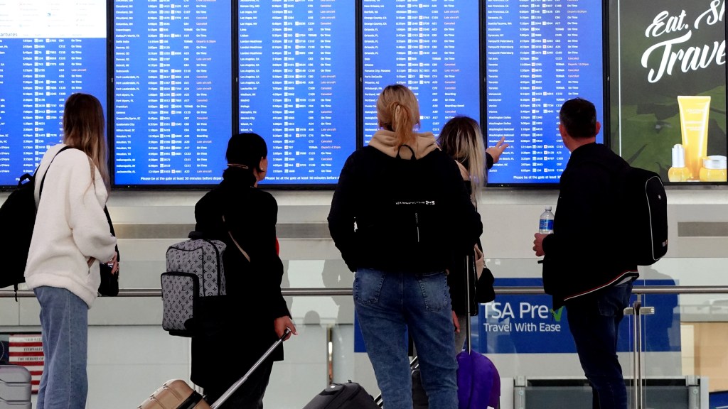 Passengers check the departures board at United Airlines Terminal C at Newark Airport, photographed on May 5, 2025.
