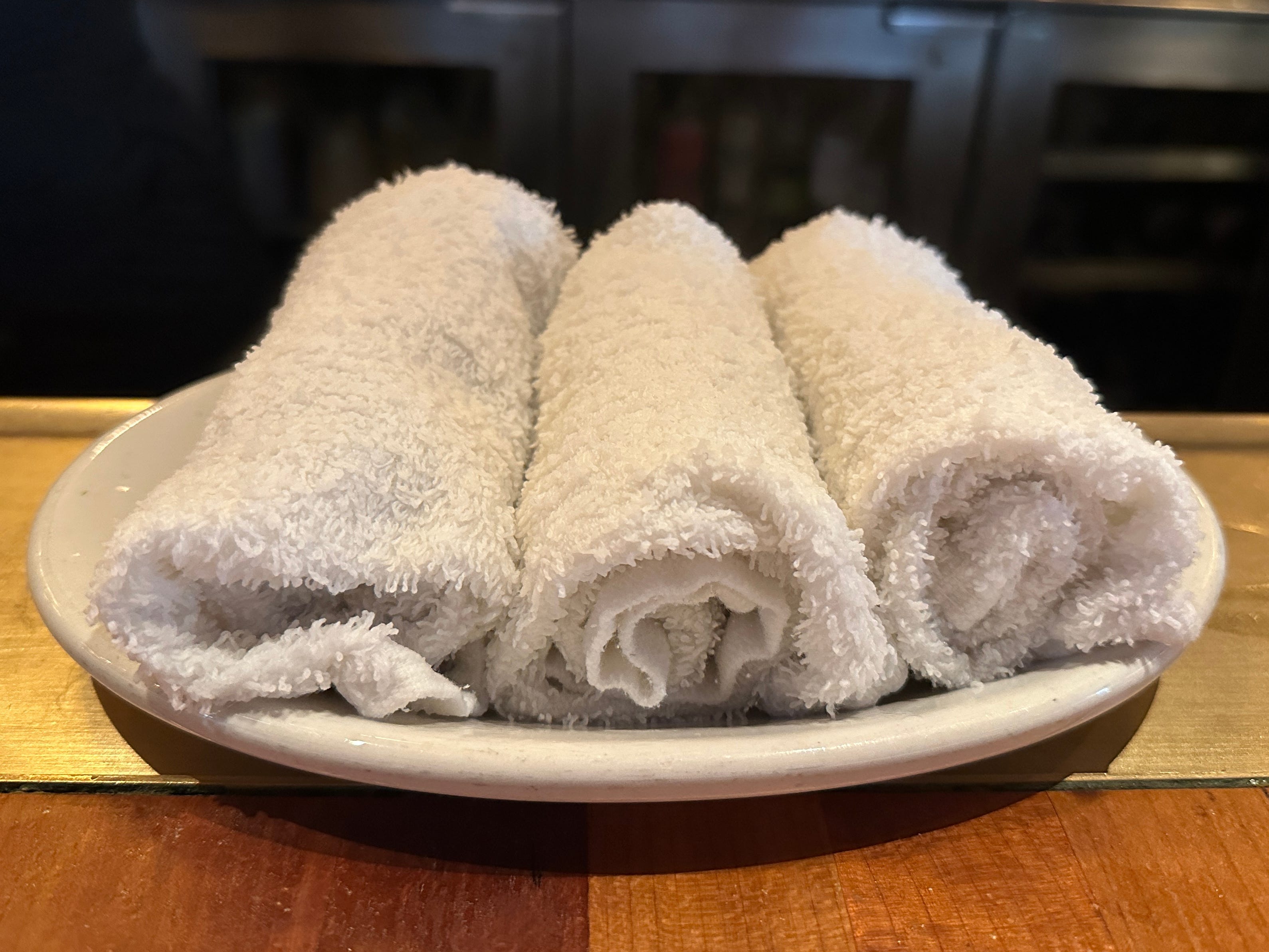Three wet hand towels on a small white plate.