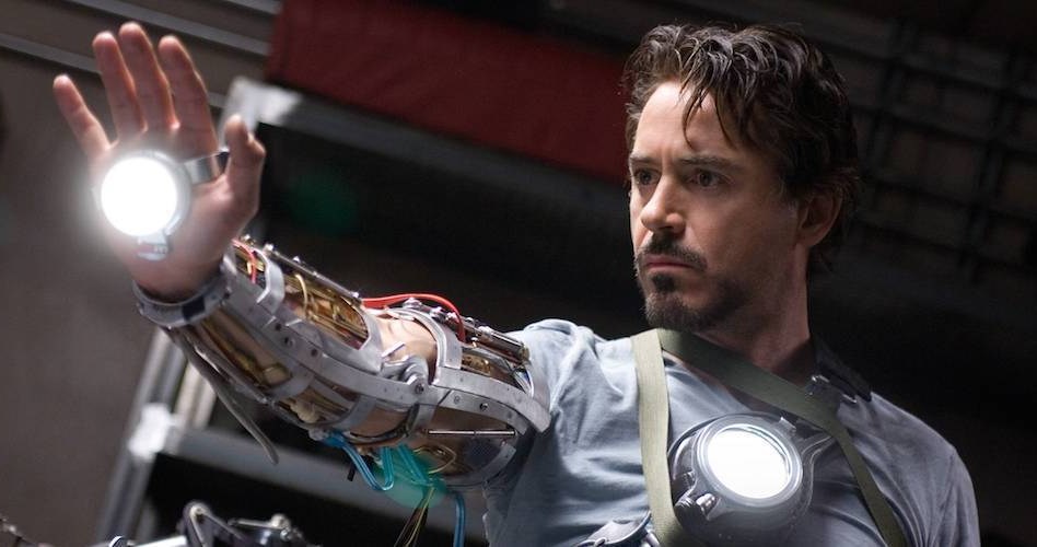 Robert Downey Jr. holds out his hand wearing an Iron Man arm in Iron Man