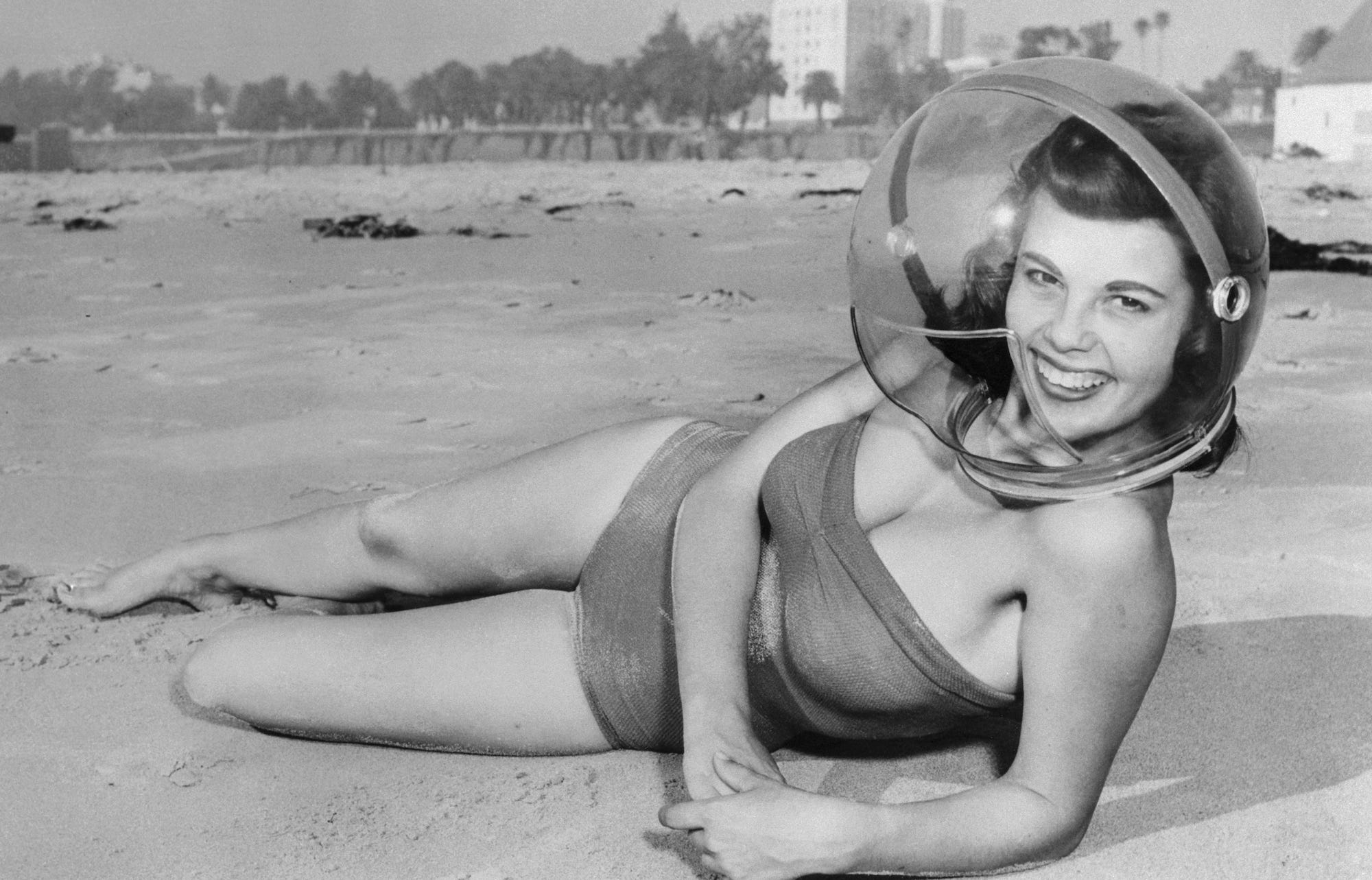 Santa Monica, California, USA. Nancy Young, 16, of Gardena, California, tries out a plastic Smog Helmet on the beach at Santa Monica. Adding to the usual plaints about smog conditions were the brush fires that sent more smoke and ashes over the Los Angeles area. It was discovered that the helmet modeled by Nancy was fine for keeping ashes away but that old Debbil smog still crept in through it.