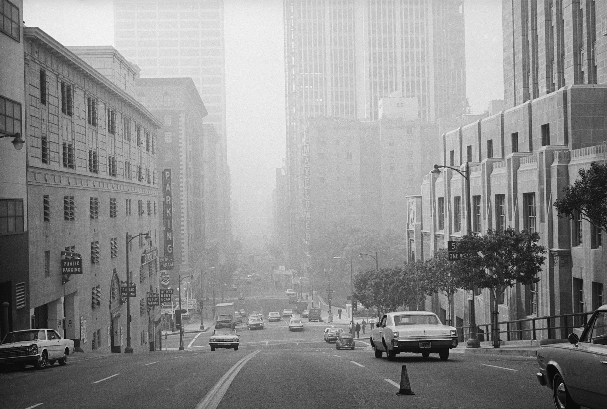Grand Avenue between 5th and 6th Streets view from the same spot 10/10/67 shows progress in building construction but not much change in smog control. Officials brag that the smog is no thicker than it was ten years ago although the population nearly doubled, which is progress of a sort.