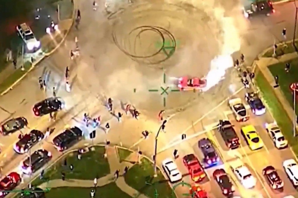 Cars takeover a downtown Kansas City intersection to perform reckless stunts.