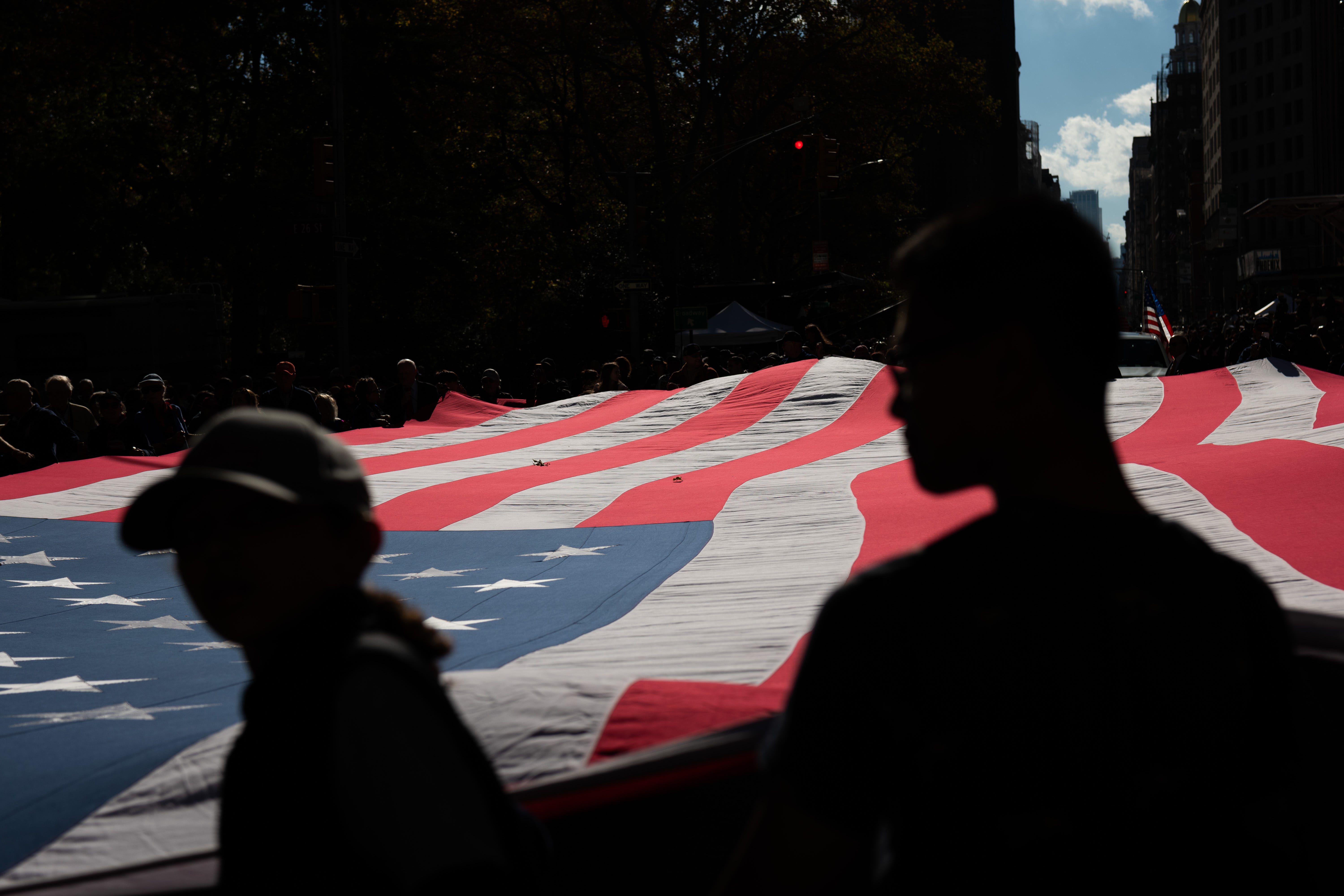 People hold the American flag during the annual Veterans Day Parade in New York City.