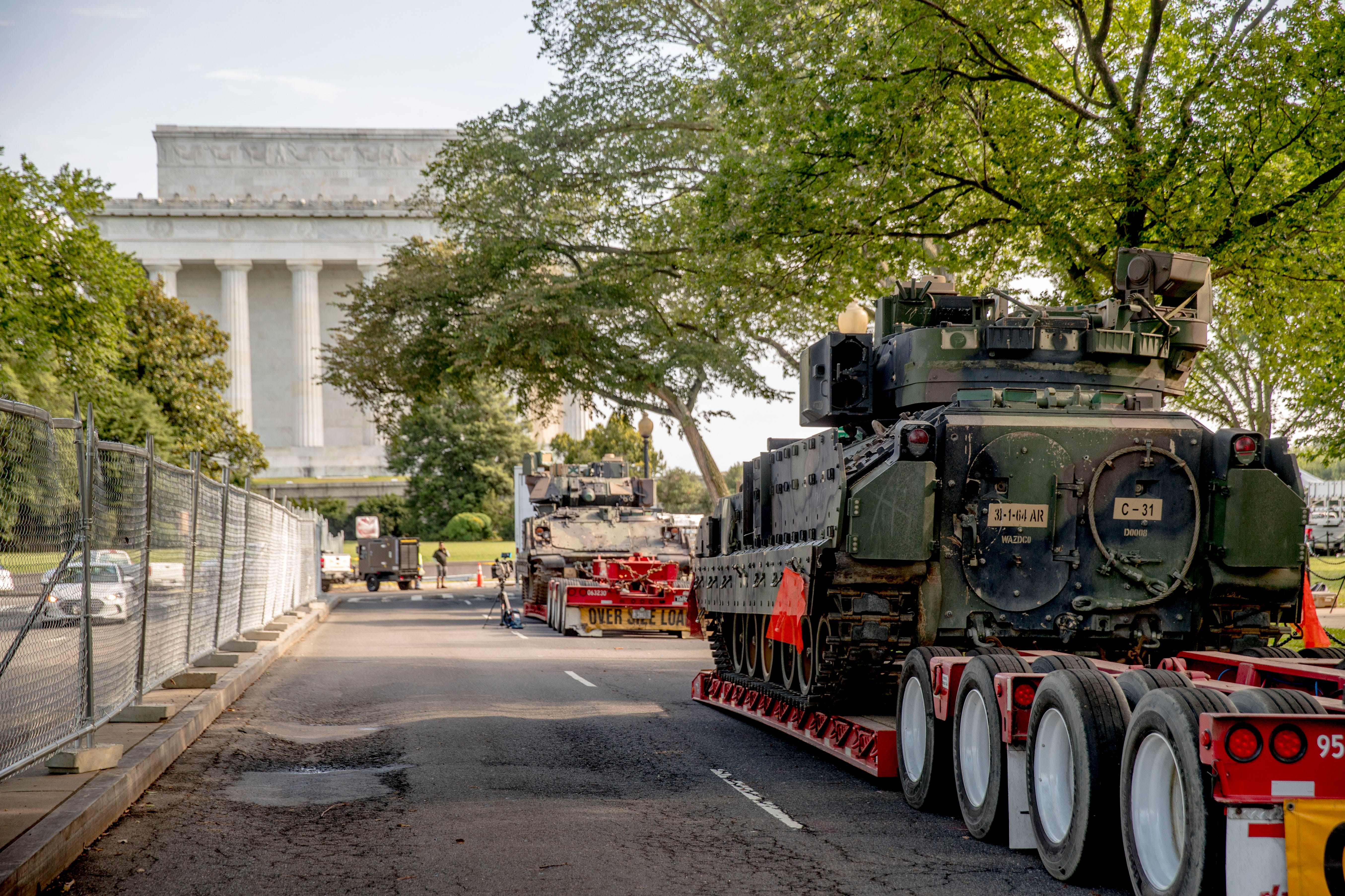 Two Bradley Fighting Vehicles are parked nearby the Lincoln Memorial.