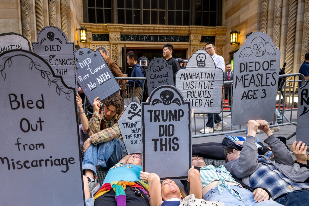 Demonstrators sprawled out on the ground outside the soiree with cardboard headstones blasting President Trump.