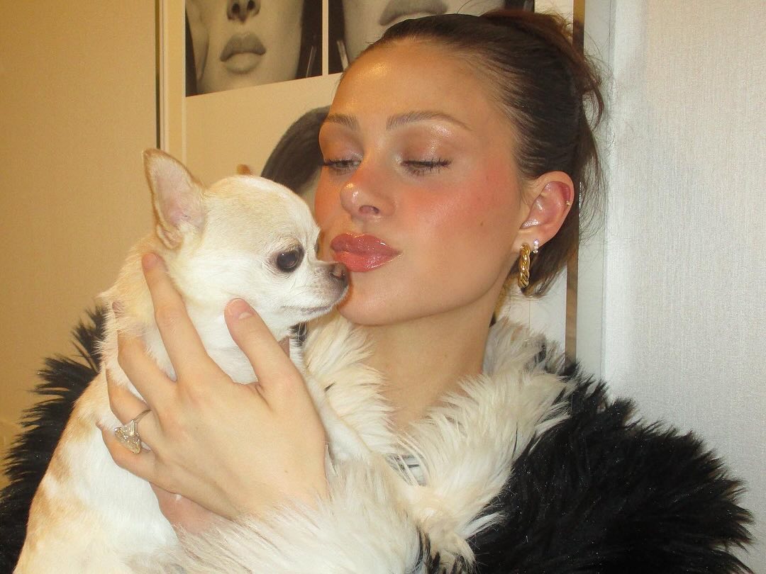 Nicola Peltz cuddles up to a dog.