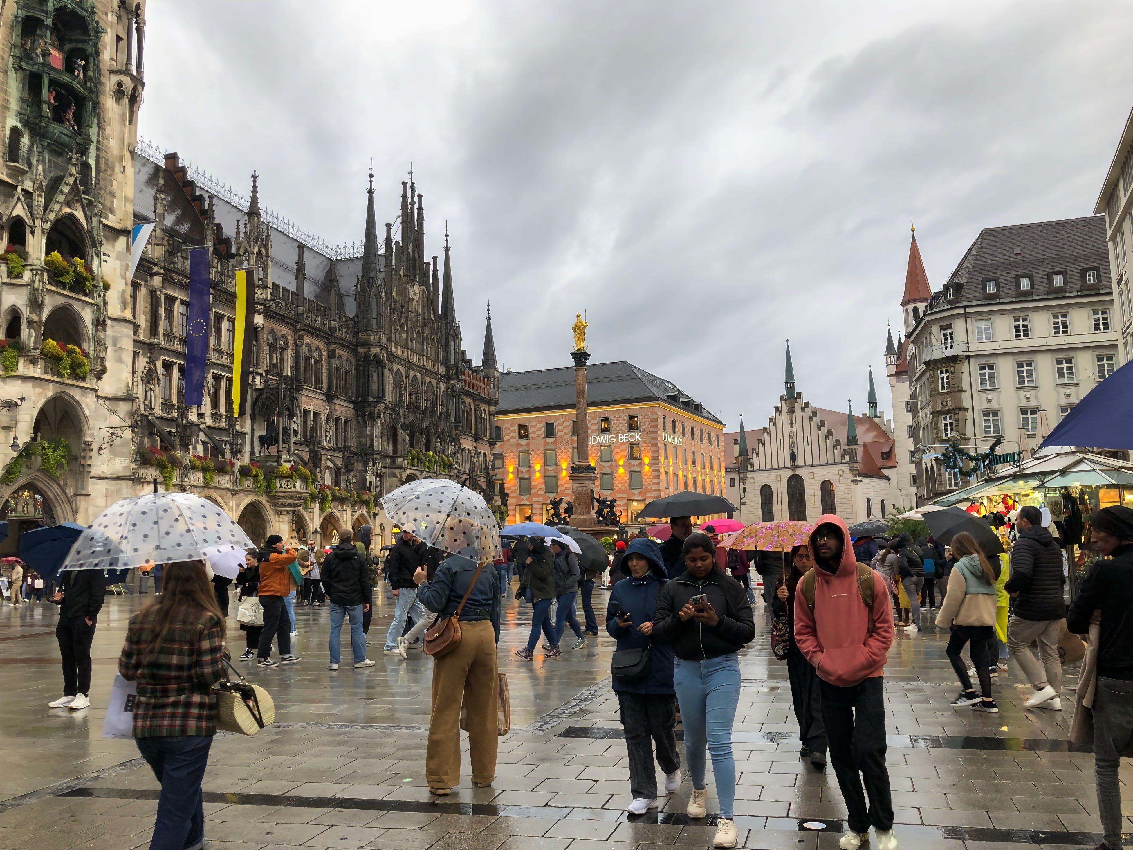 People walking in Munich in the rain, some with umbrellas