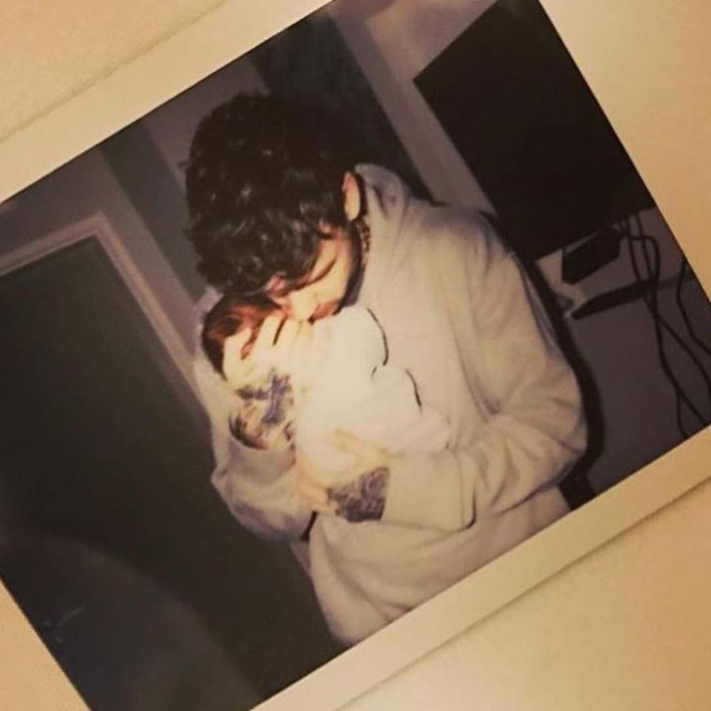 Liam Payne cradling a very small baby