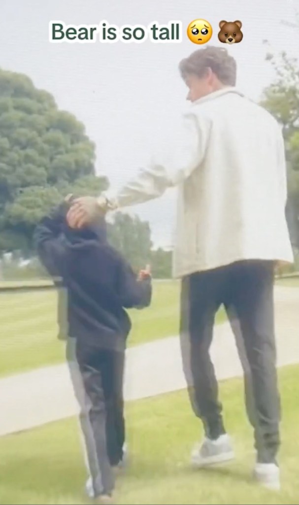 Liam Payne in a cream jacket and black pants, walks with Bear Payne in a dark sweater and black pants.