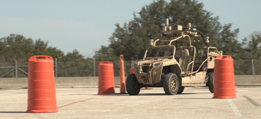 In this screenshot from a 2021 video, a robotic vehicle maneuvers around obstacles at DEVCOM Ground Vehicle Systems Center in Detroit, Michigan.