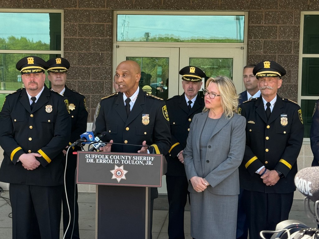 Suffolk Sheriff Errol Toulon presents the county’s Top 10 list of deadbeat dads standing alongside Suffolk County Legislator Trish Bergin.