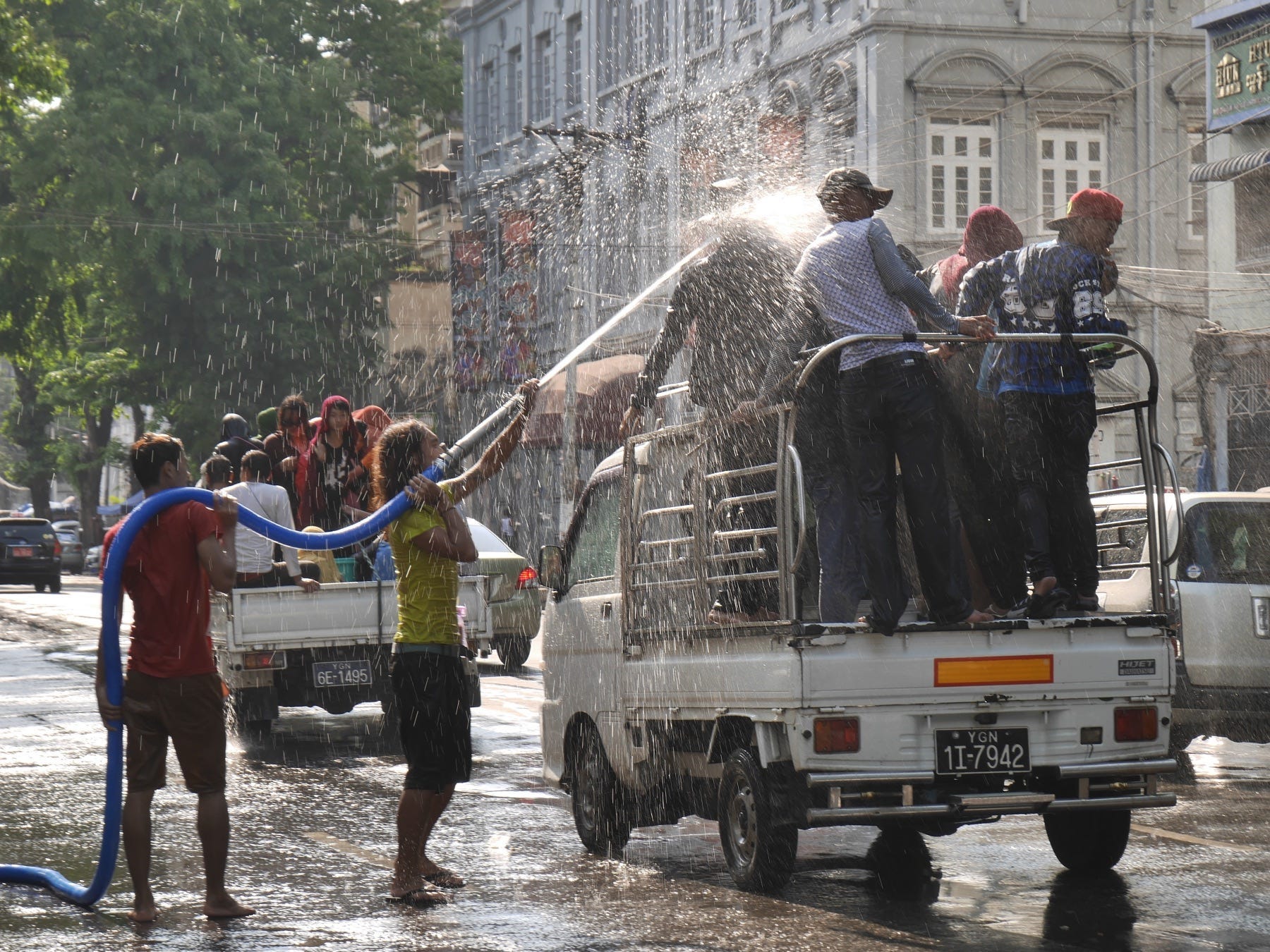 Shooting water at people on a white truck during the Thingyan Festival, Myanmar's New Year celebration.