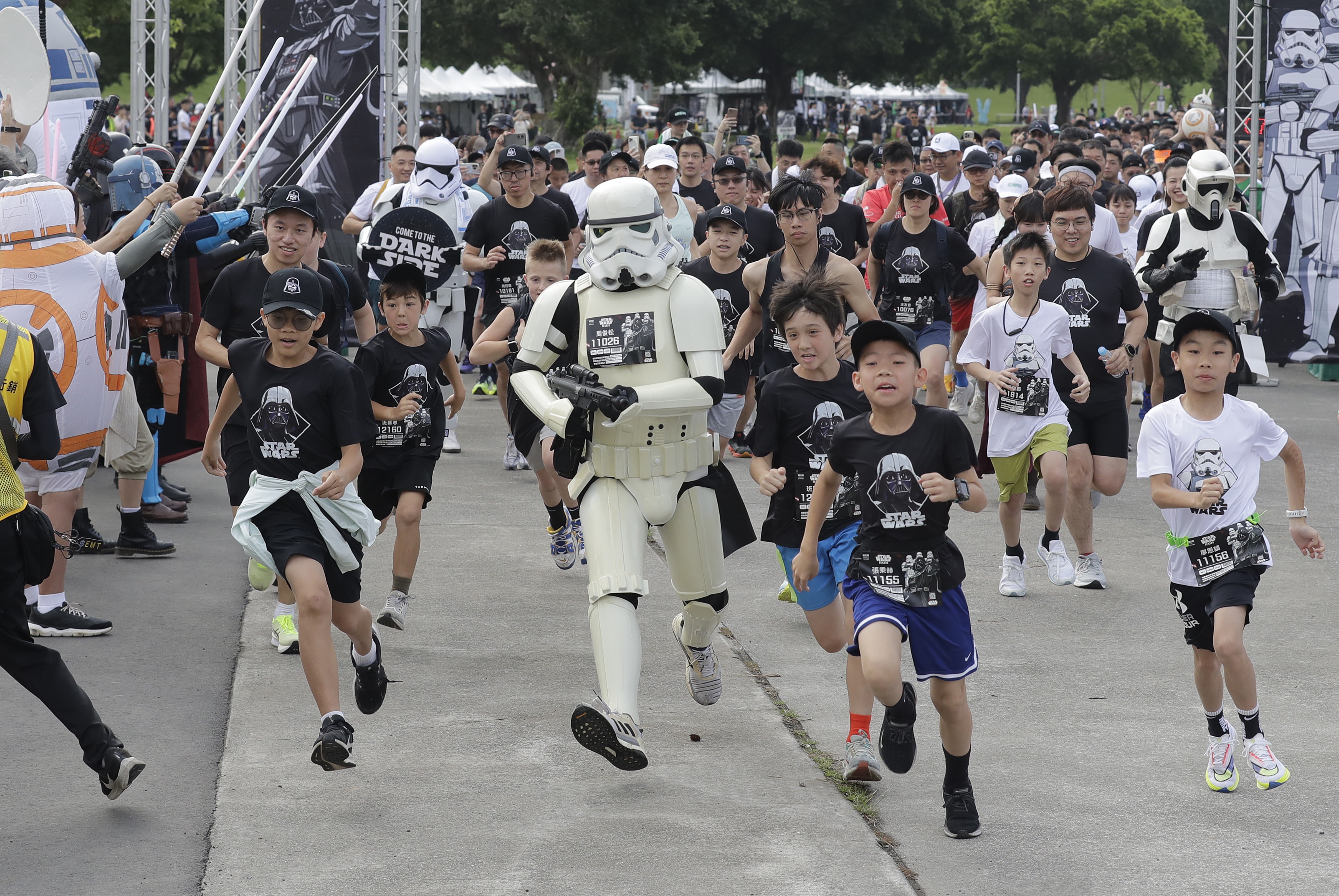 Children and adults run in a race, with some runners, dressed as characters from Star Wars.