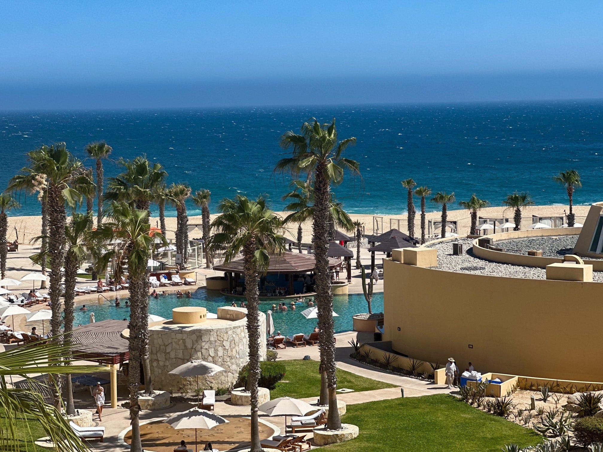 View of pools, beach, palm trees from a resort in Cabo