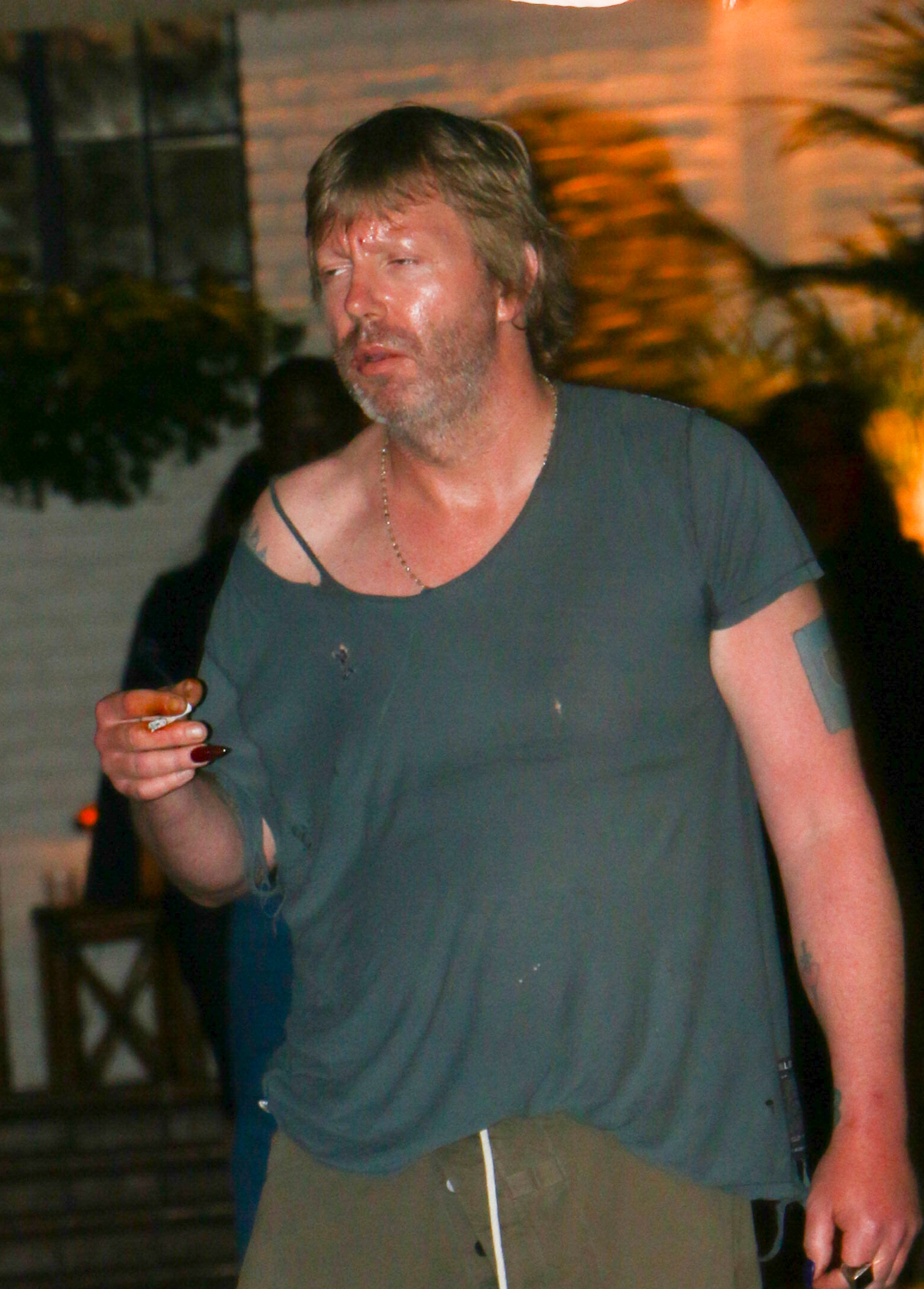 Elijah Blue Allman outdoors at night looking disheveled. 
