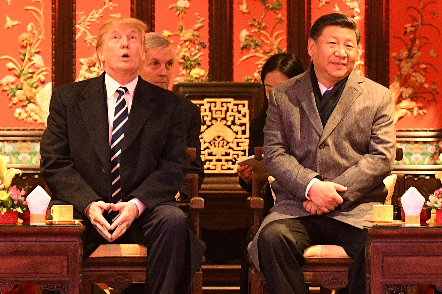 U.S. President Donald Trump looks up while seated beside Chinese President Xi Jinping at the Forbidden City.