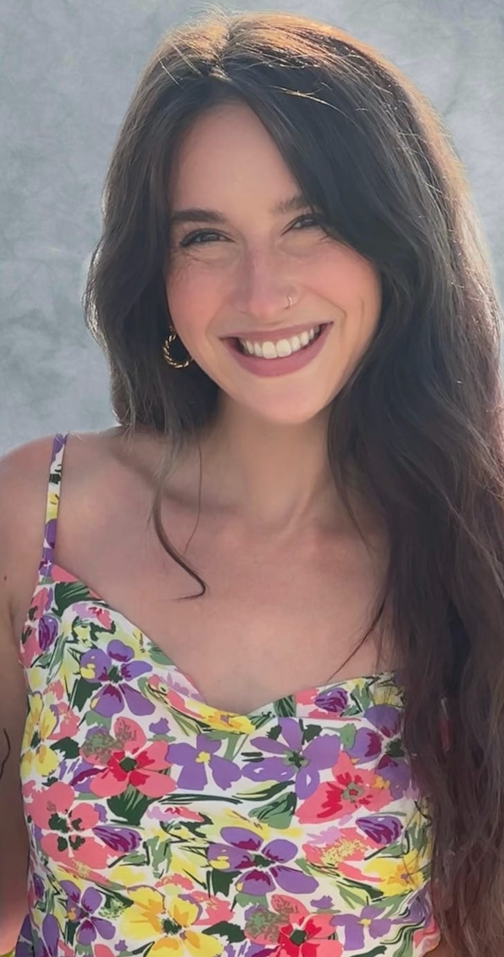 Image of Amelia Samson in a floral top, smiling.
