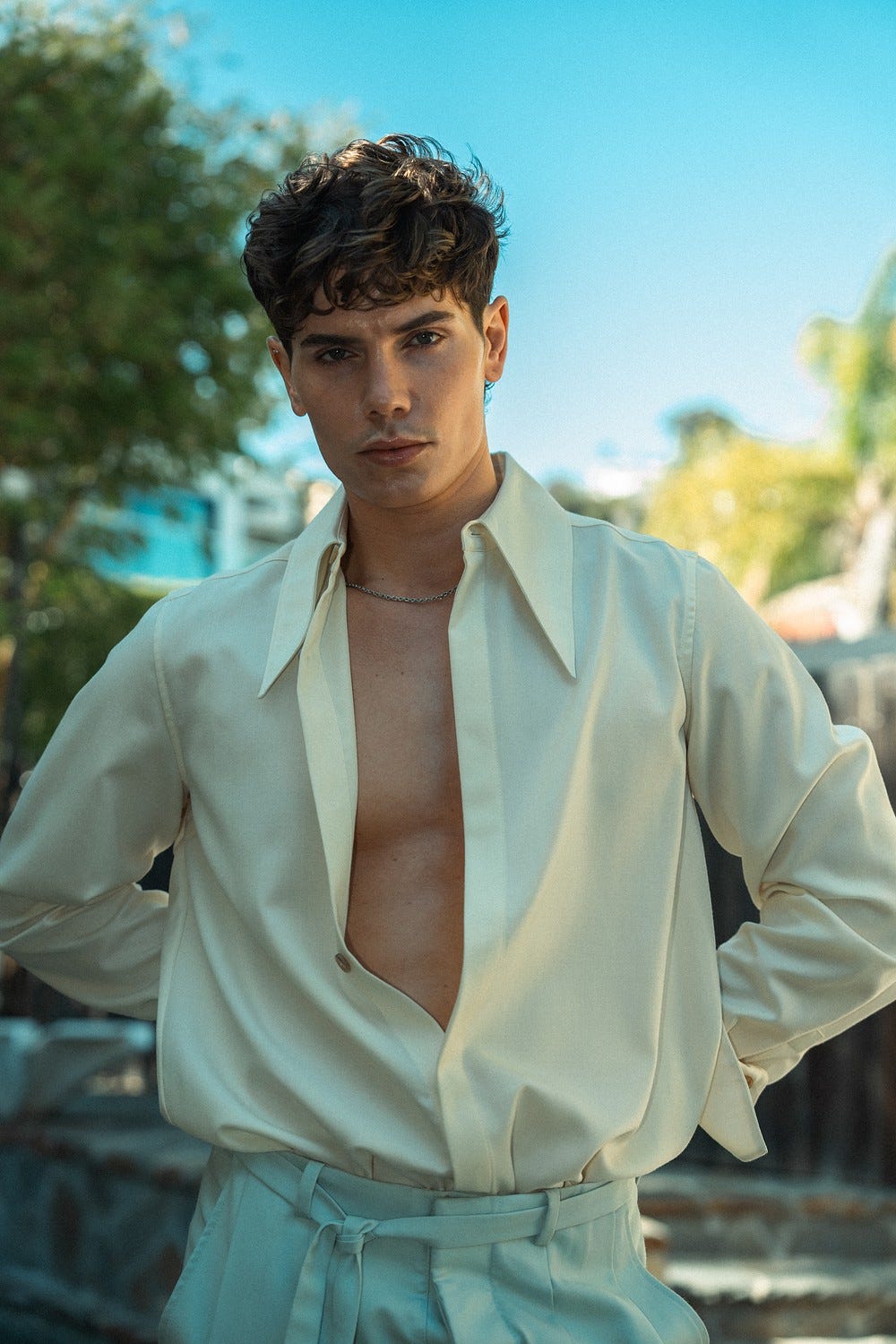 Nick Champa wearing a white shirt unbuttoned.