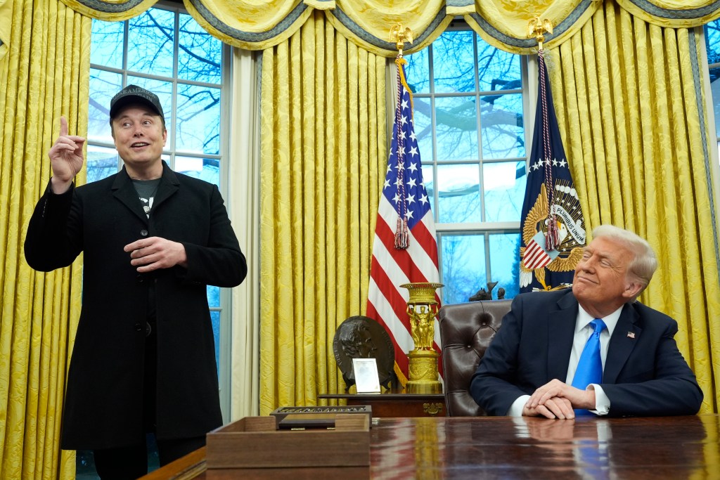 President Donald Trump and DOGE leader Elon Musk speak to reporters inside the Oval Office of the White House on Feb. 11, 2025.