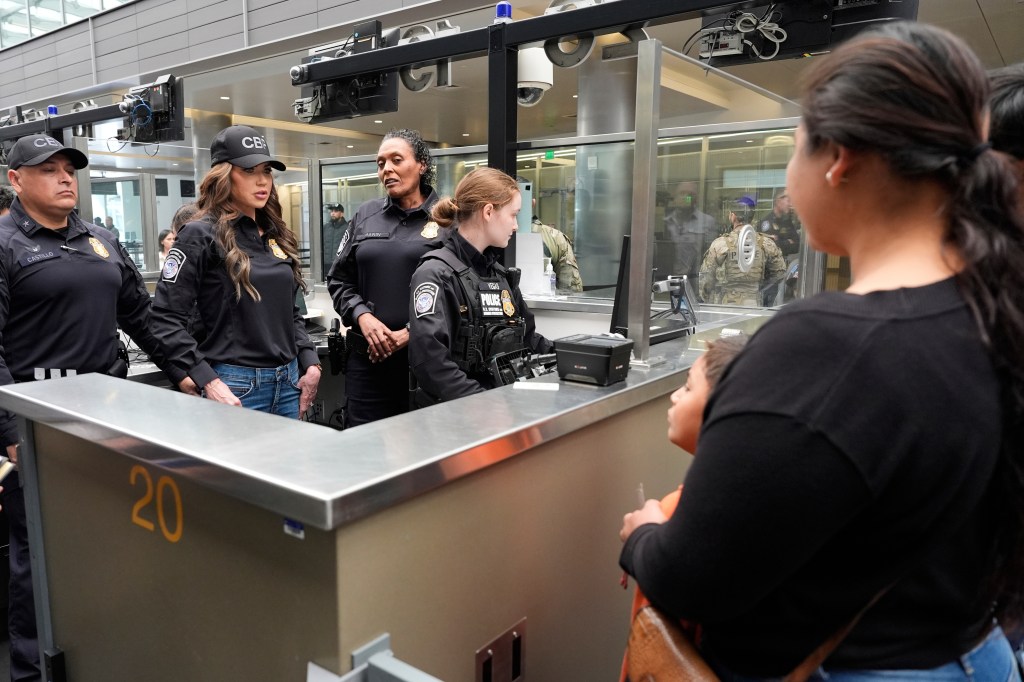 Homeland Security Secretary Kristi Noem, second left, watches as officers check people passing through the border during a tour of the San Ysidro Port of Entry, Sunday, March 16, 2025, in San Diego. 