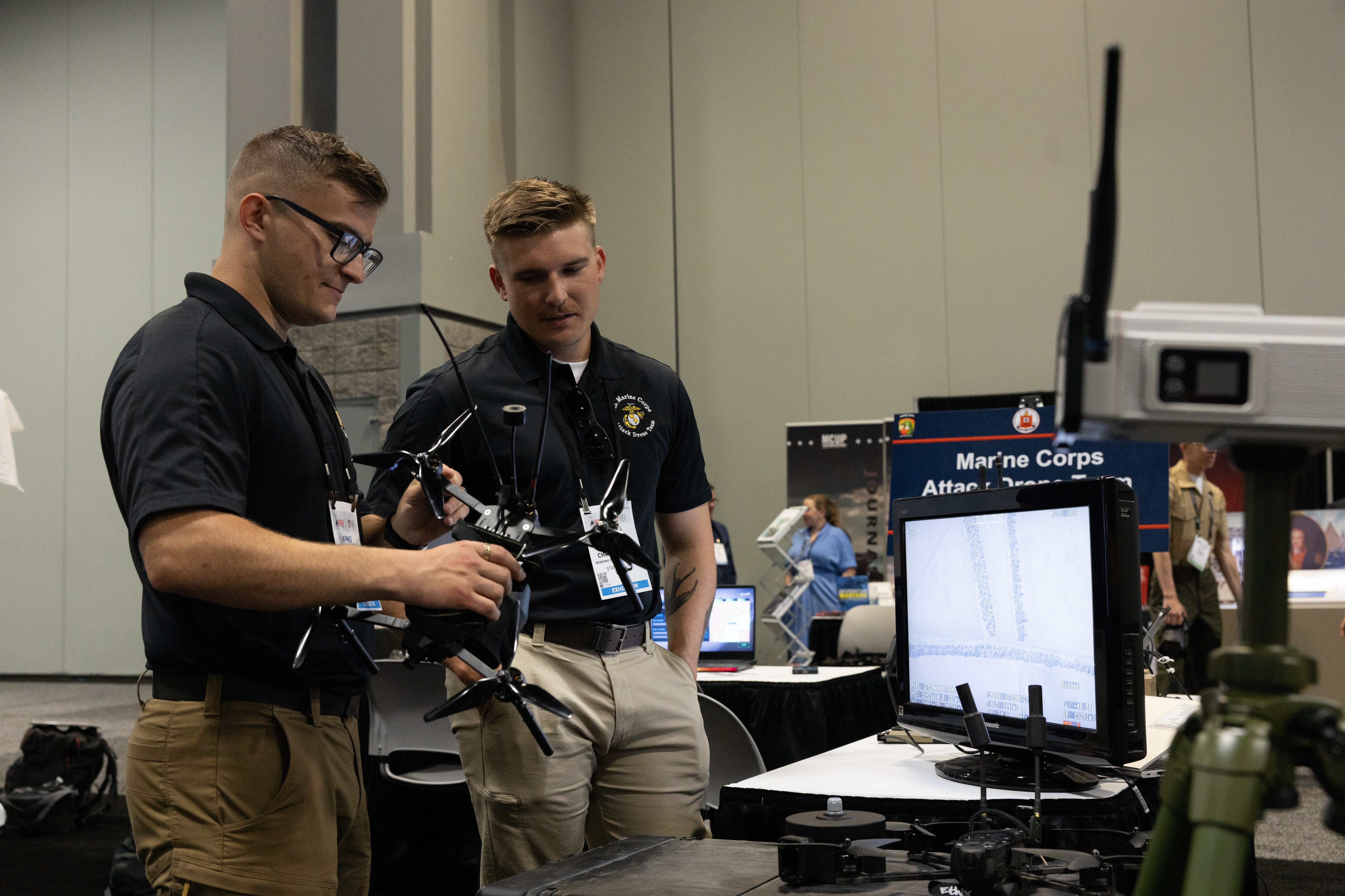 Marines assigned to the Corp's Attack Drone Team handle a small drone at the Modern Day Marine expo in Washington, D.C., April 30, 2025.