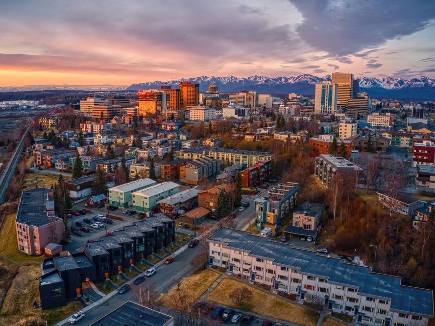 The skyline of Anchorage, Alaska with mountains in the background.