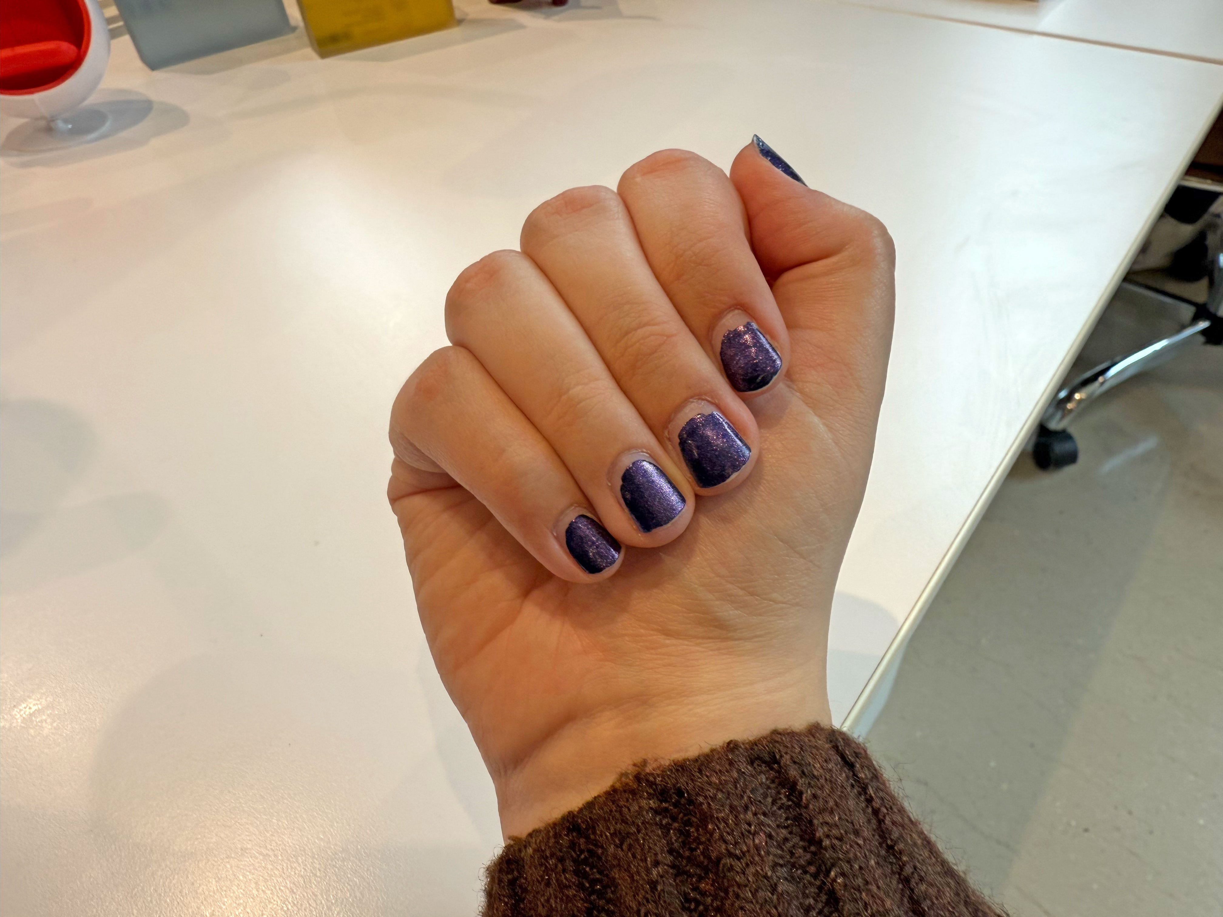 Gia's nails with grown-out sparkly purple polish.
