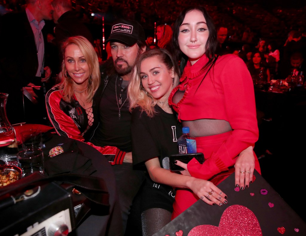 Tish Cyrus, and singers-songwriters Billy Ray Cyrus, Miley Cyrus, and Noah Cyrus pose with a sign reading 'I heart Noah Cyrus' during the 2017 iHeartRadio Music Awards which broadcast live on Turner's TBS, TNT, and truTV at The Forum on March 5, 2017 in Inglewood, Calif