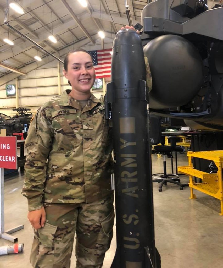 Julia Byrne in her army uniform next to what appears to be equipment