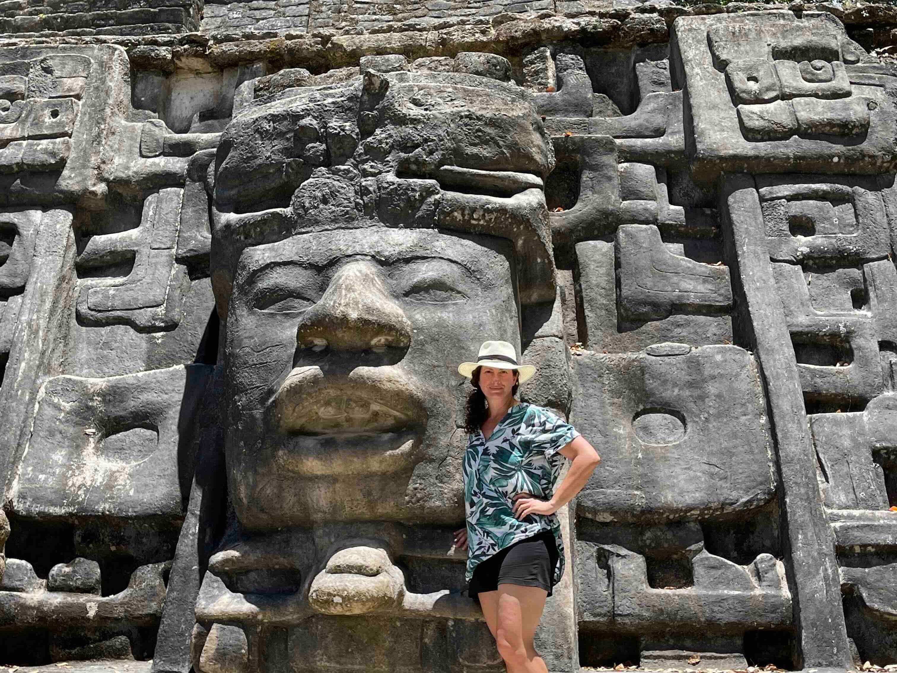 Woman posing in front of Mayan ruins in Belize.