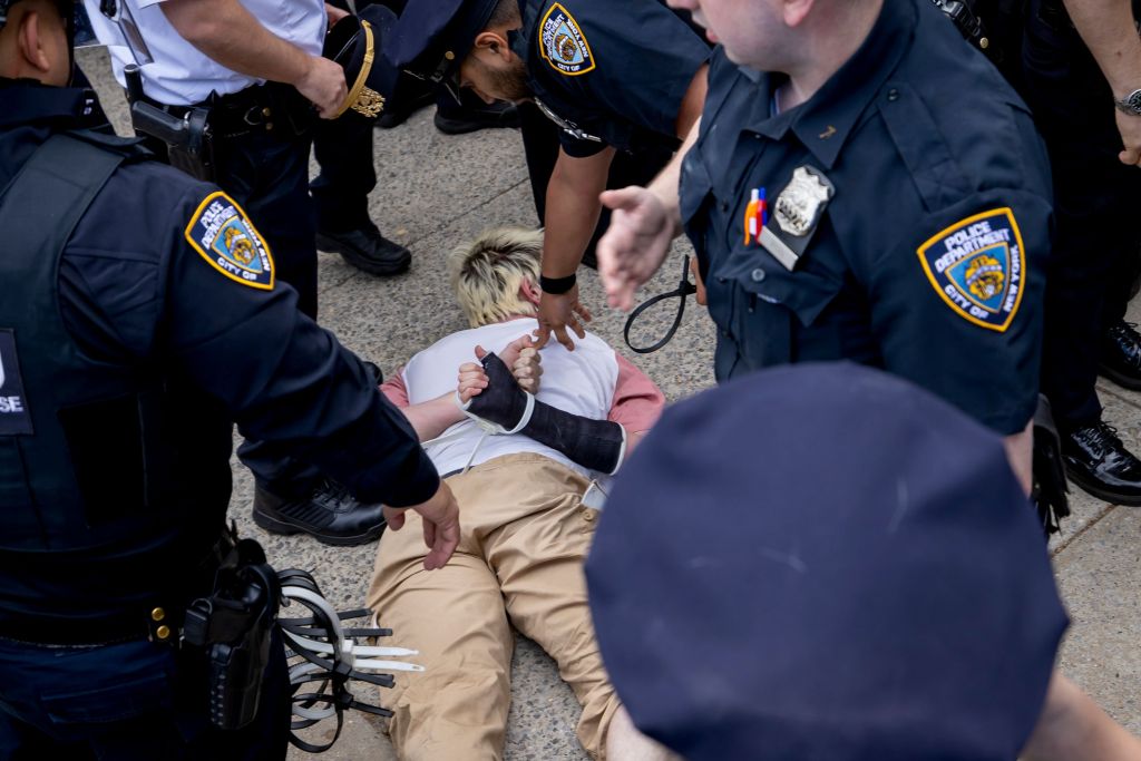 Protester with cast on right arm being handcuffed by NYPD during student-led pro-Palestine protest at Brooklyn College on May 8, 2025