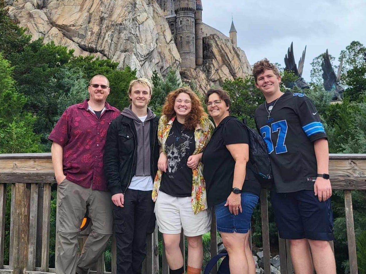 The Richardson family in Orlando on vacation on a bridge in front of a castle-like structure.