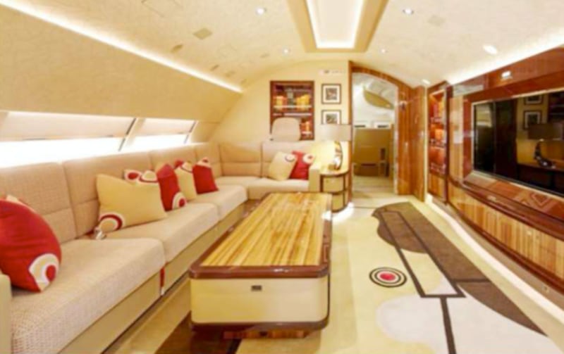A living room on the upper deck features an L-shaped couch, built-in bookshelves, and built-in big-screen TV.