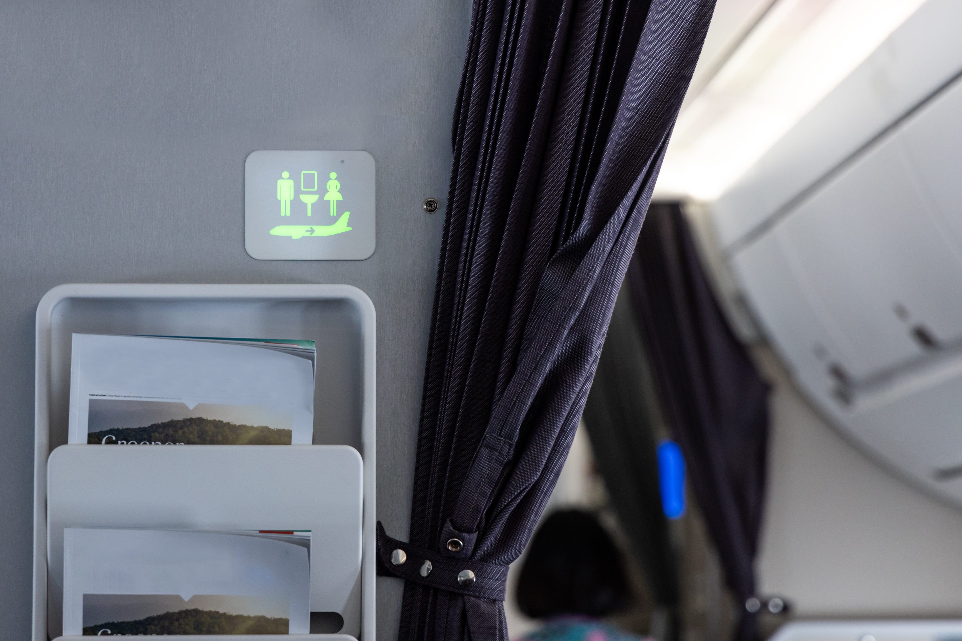 Lit-up lavatory sign in plane cabin