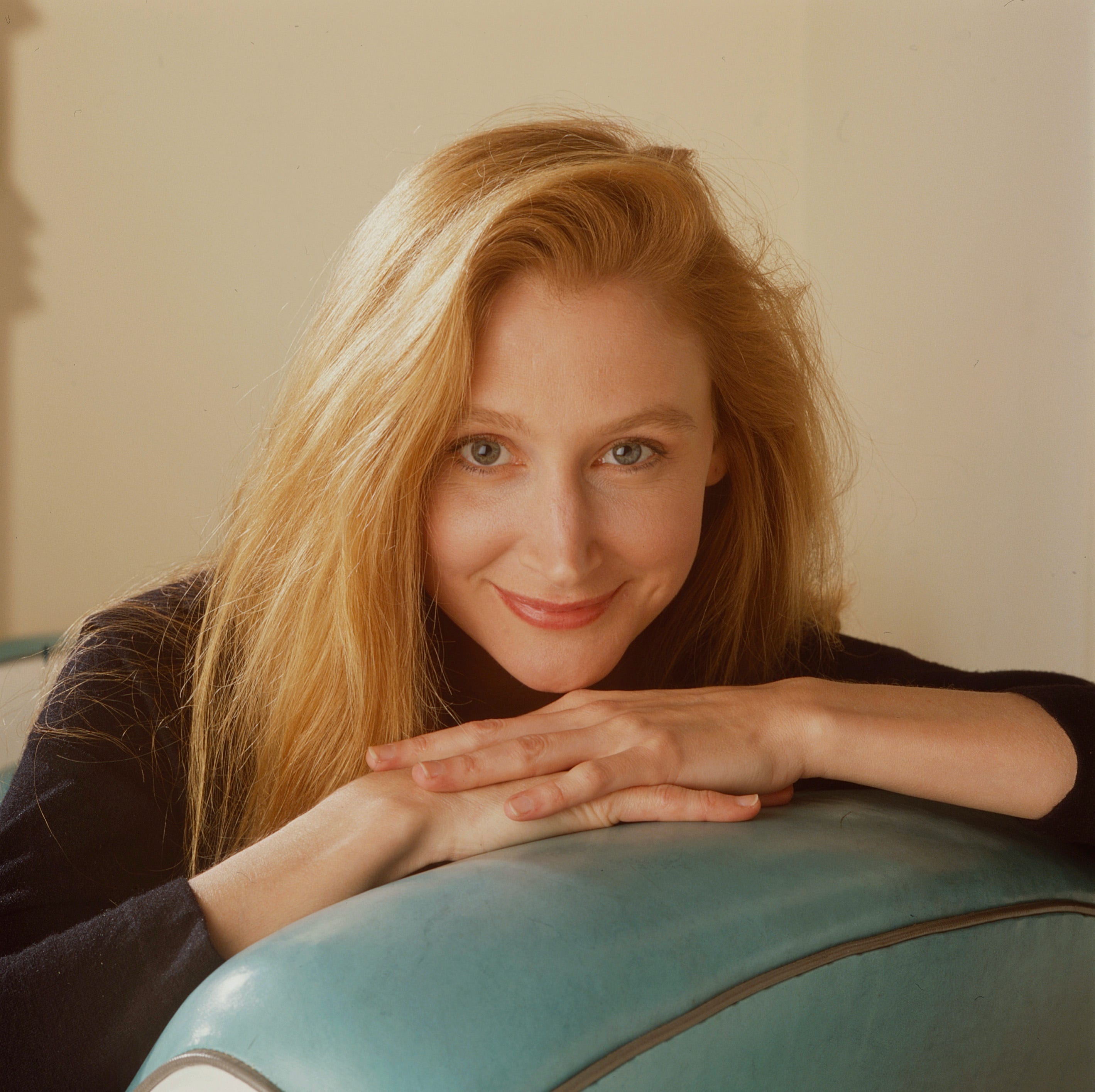 Patricia Clarkson leaning on a couch cushion