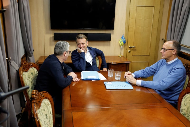 France's President Emmanuel Macron (C), Britain's Prime Minister Keir Starmer (L) and German Chancellor Friedrich Merz (R) hold a trilateral meeting on board a train to Kyiv, in Shegyni, Ukraine, on May 9, 2025.