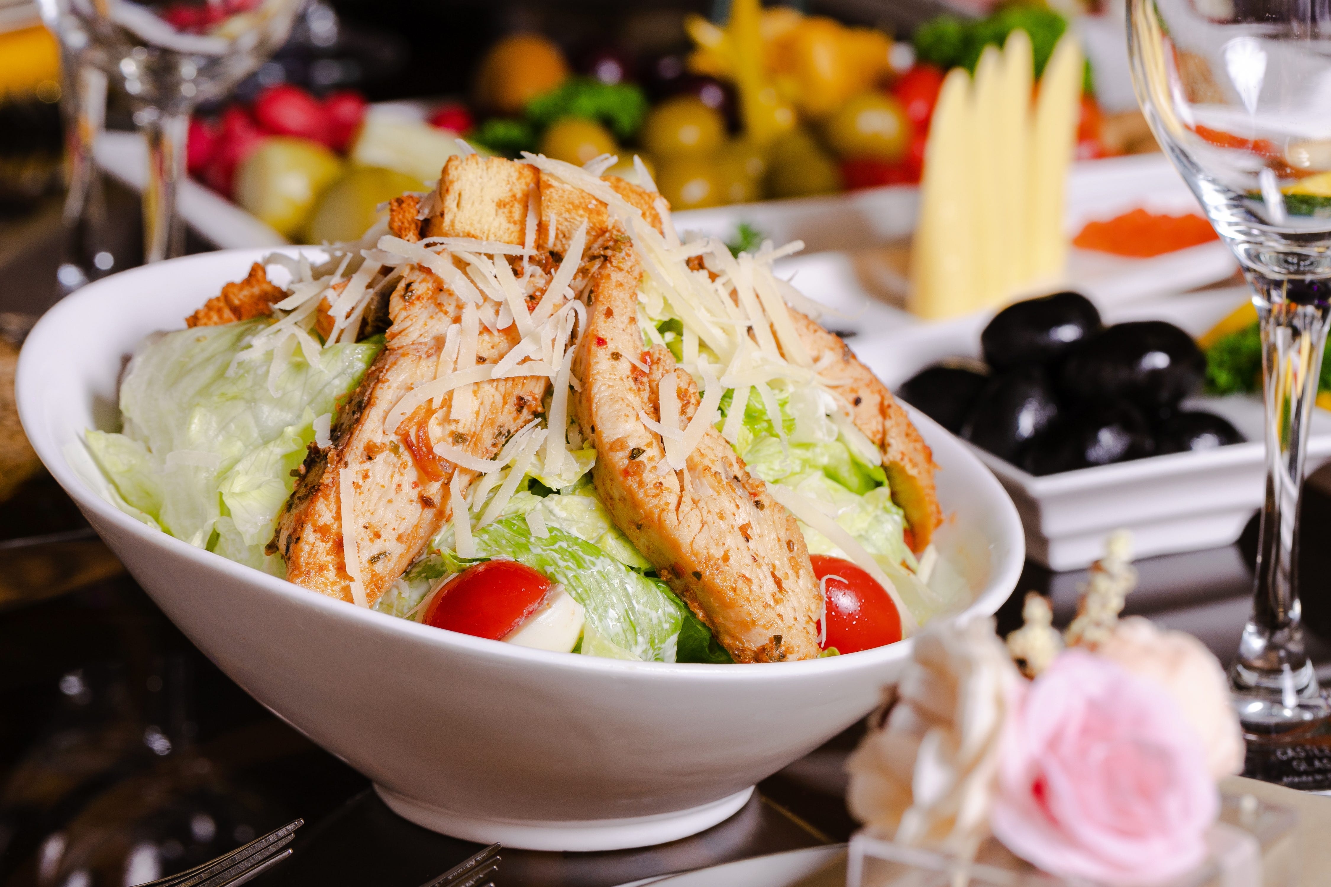 Cesar salad topped with croutons, chicken