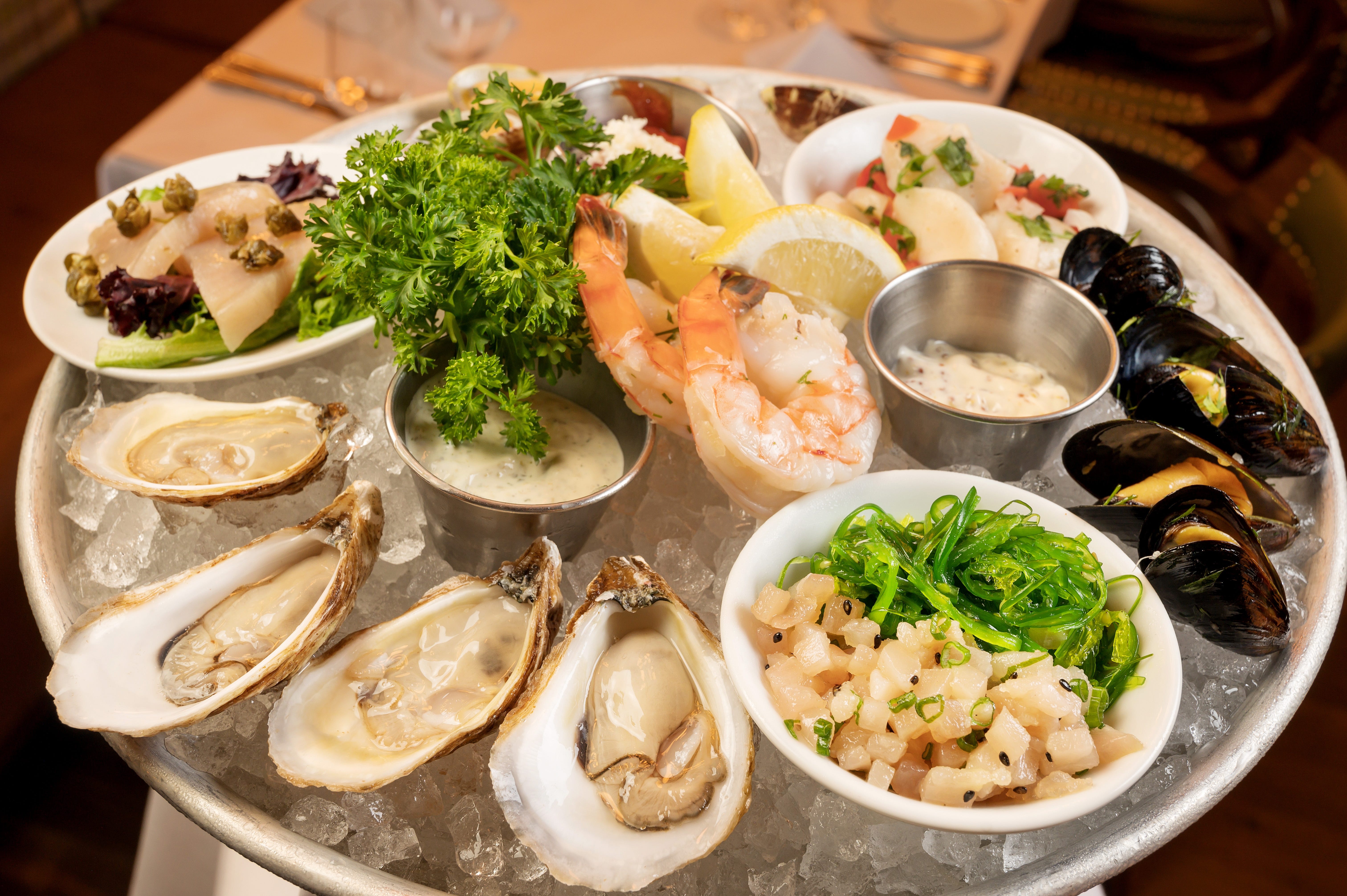 Oysters on ice on platter with other seafood items