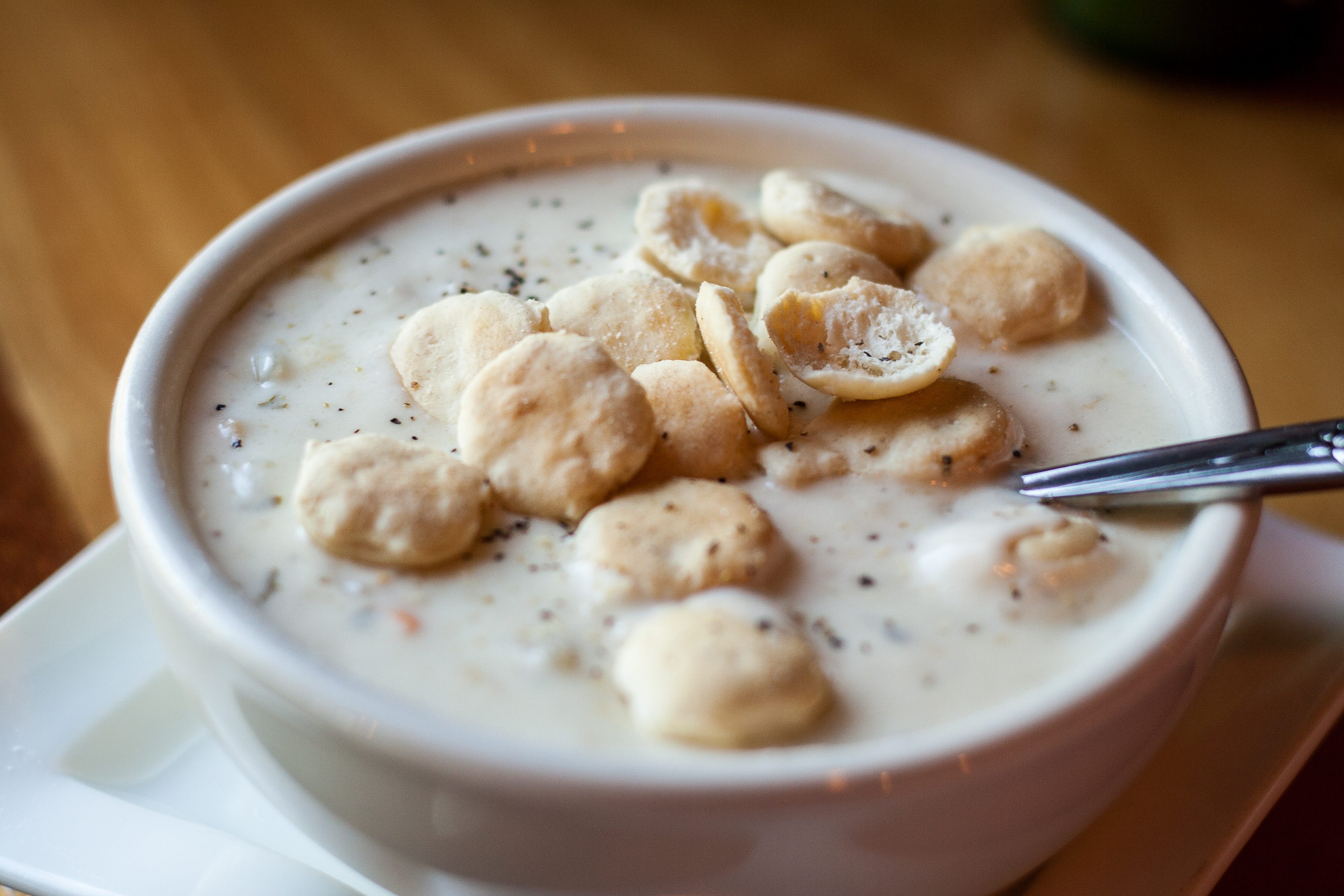New England clam chowder in bowl with oyster crackers on top