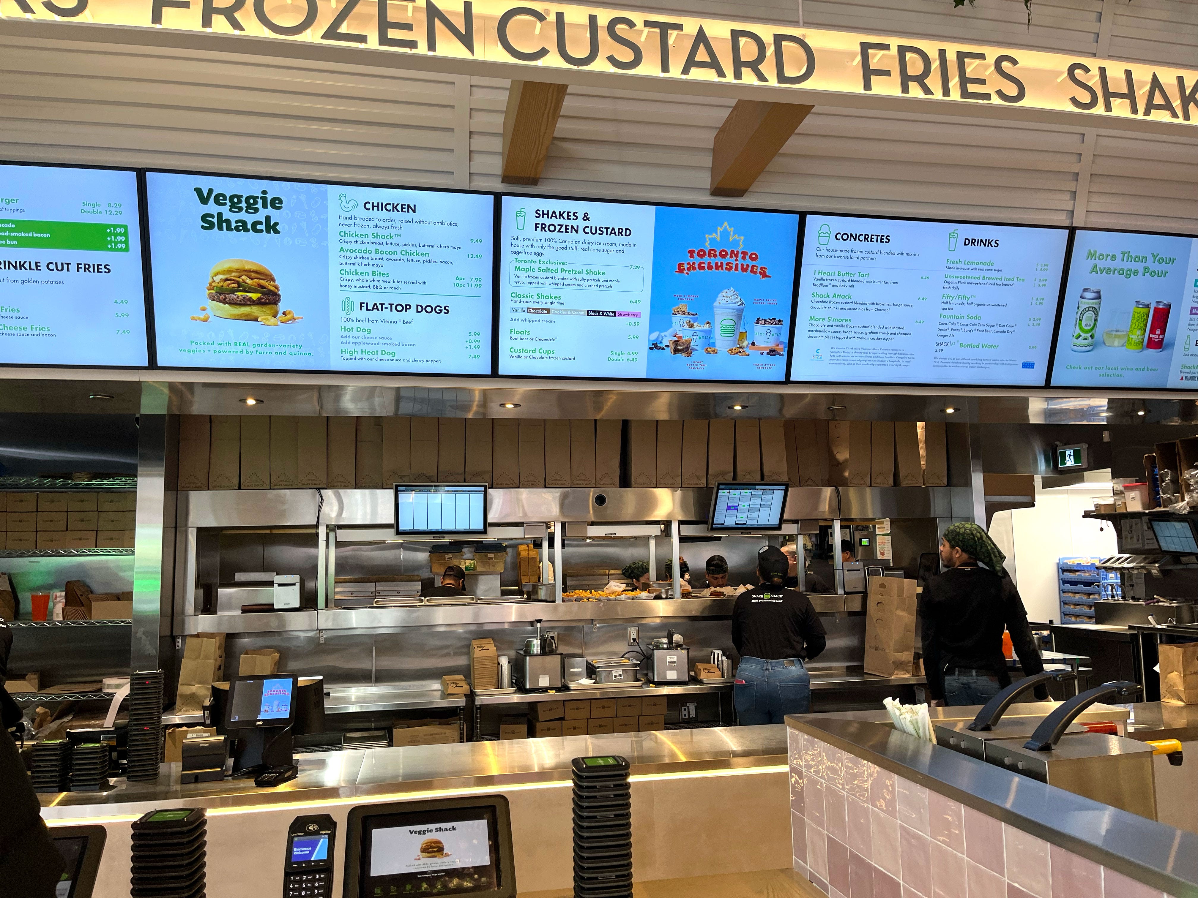 The counter of a Shake Shack restaurant with digital menus.