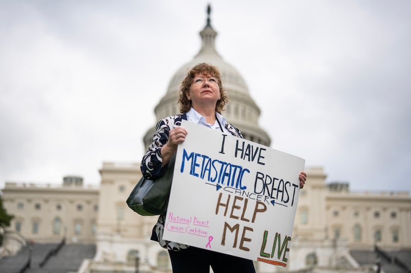 A woman attends a rally on the West Front of the U.S. Capitol to support research and policies for breast cancer treatment, that are at risk by proposed Medicaid cuts.