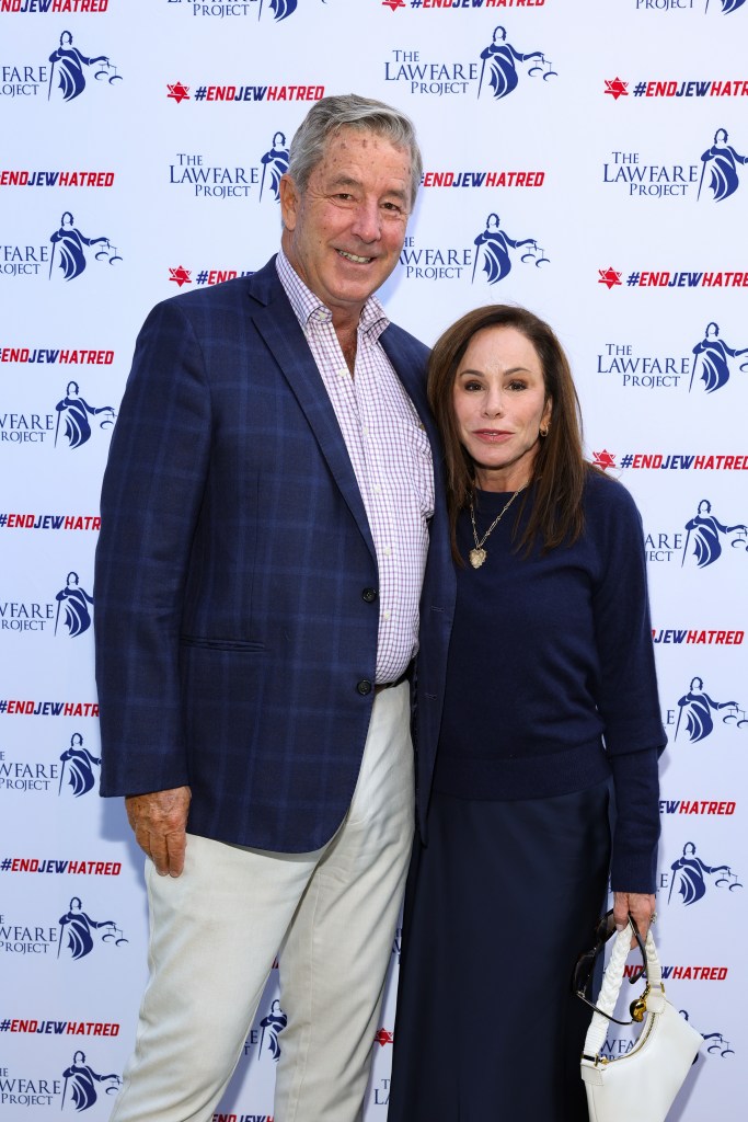 Melissa Rivers in a black top and black pants, Steve Mitchel in a navy blue blazer, red checked shirt and cream pants.