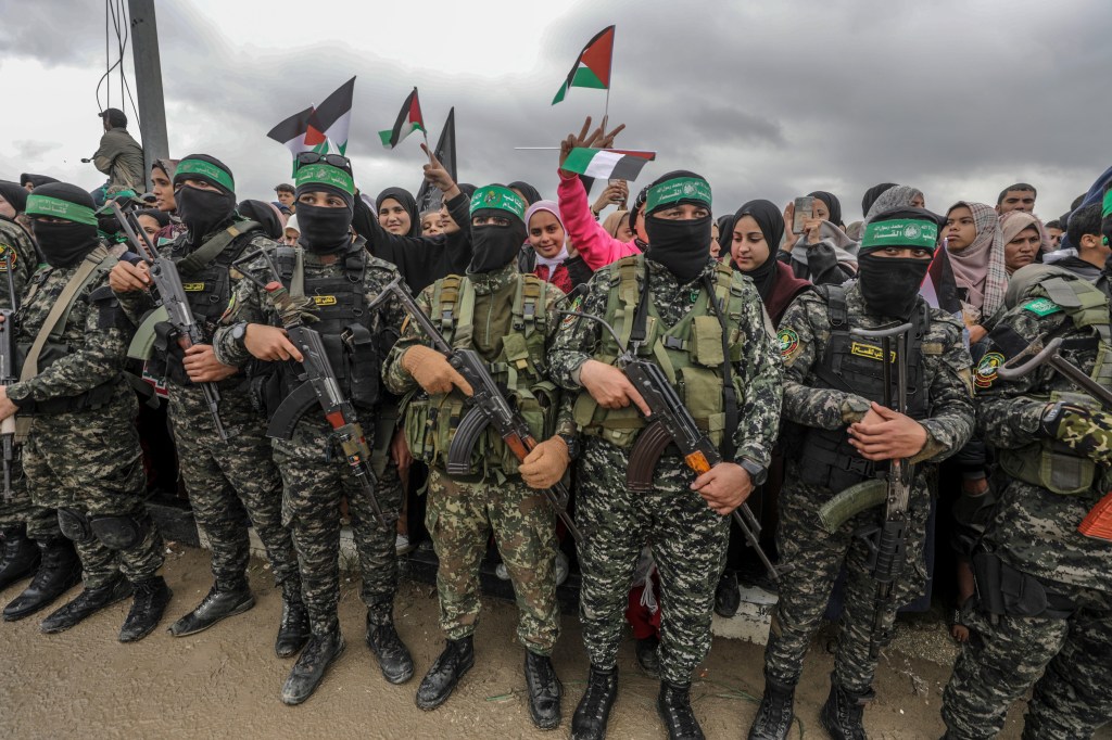 Armed Hamas fighters during the handover of Israeli hostages to Red Cross representatives in Al Nuseirat refugee camp, Gaza in February 2025