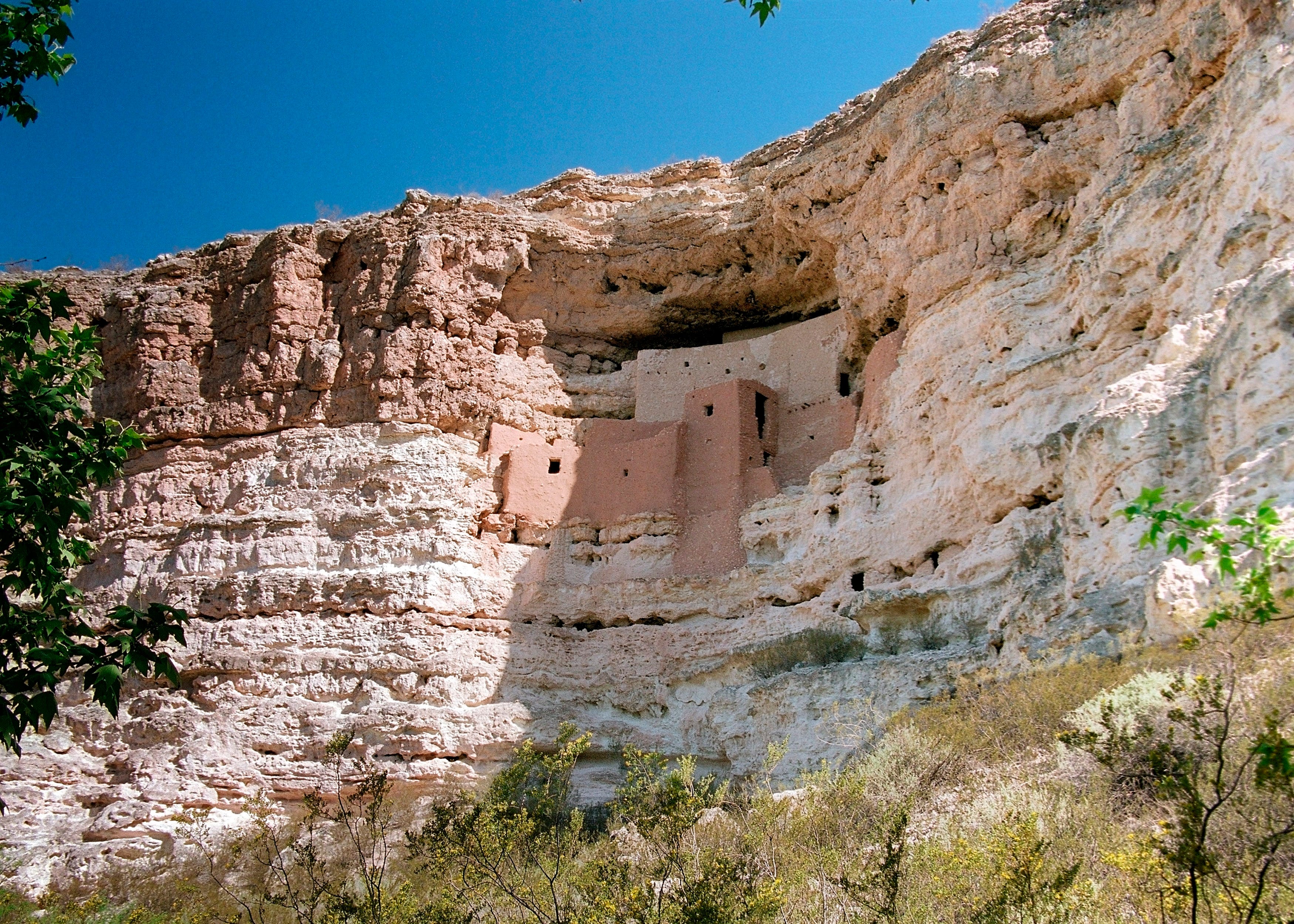 Montezuma Castle built into a cliff with orange and beige bands of color